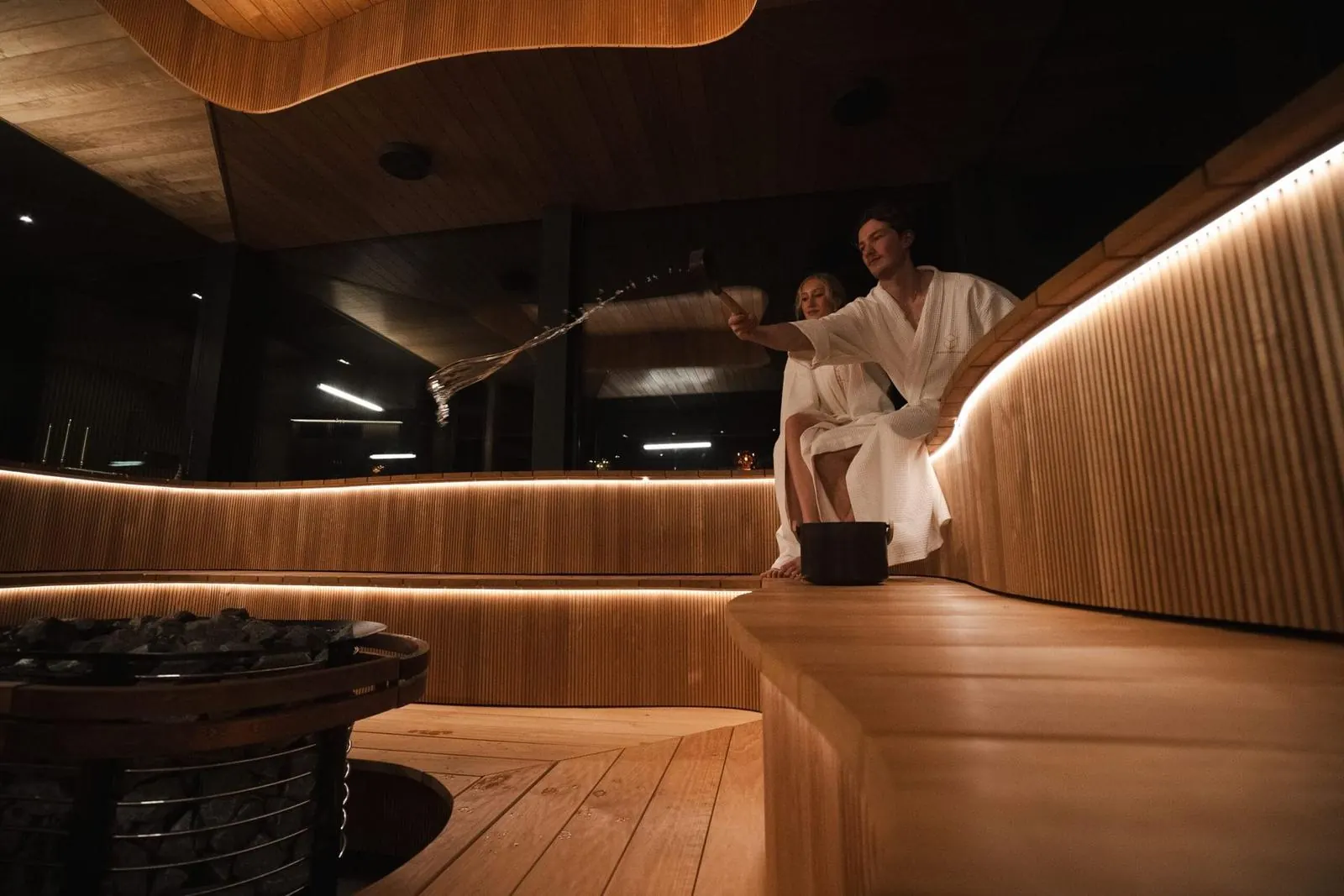 Hóspedes a relaxar na sauna Wave com vista para a floresta