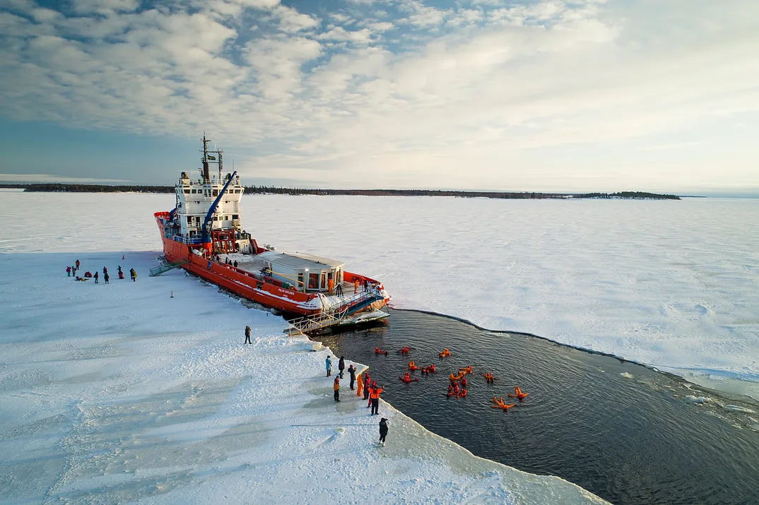 Brise-glace Polar Explorer à côté de personnes flottant dans un bassin creusé dans la banquise
