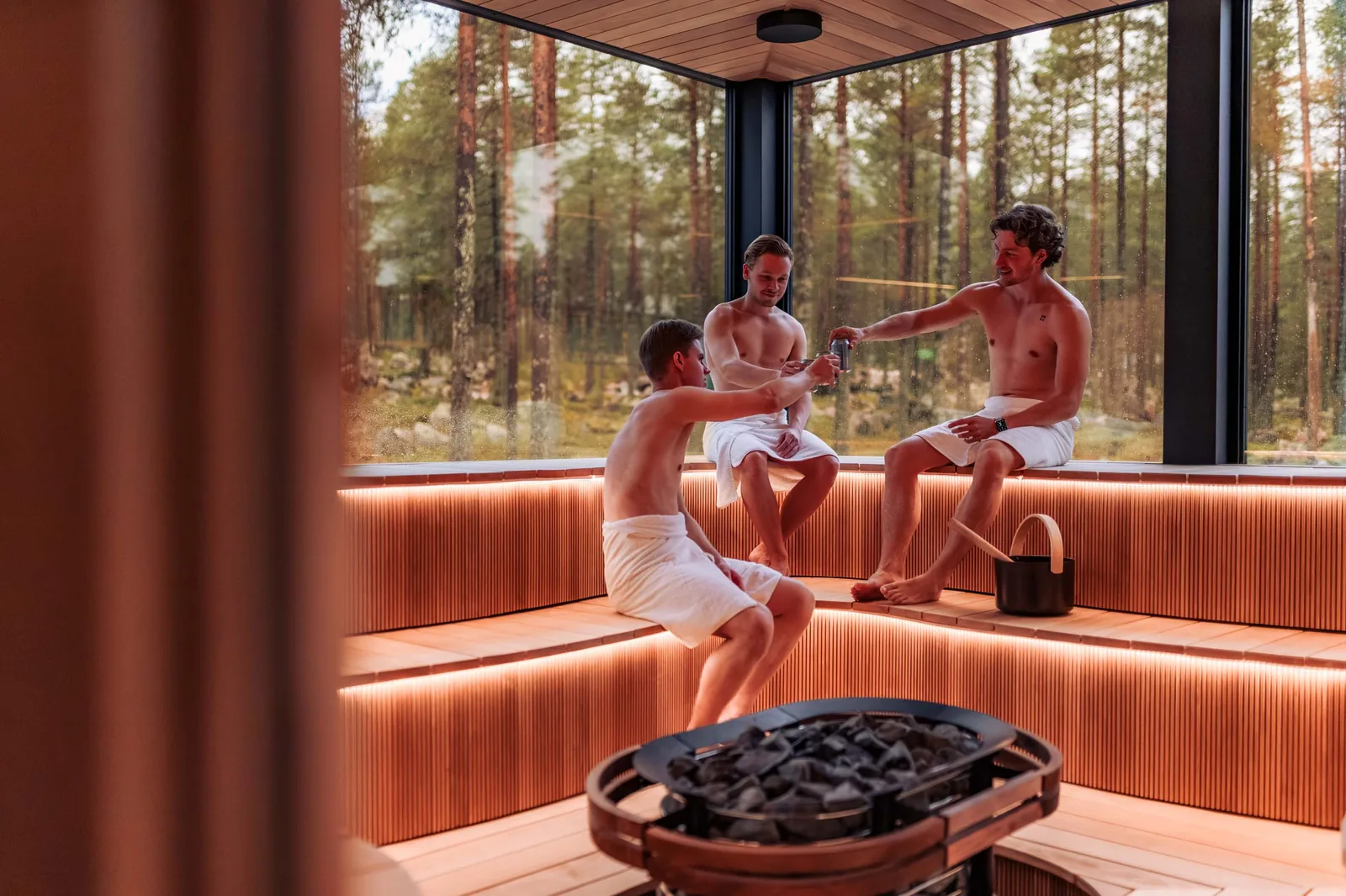 Amigos a brindar na sauna panorâmica Wave