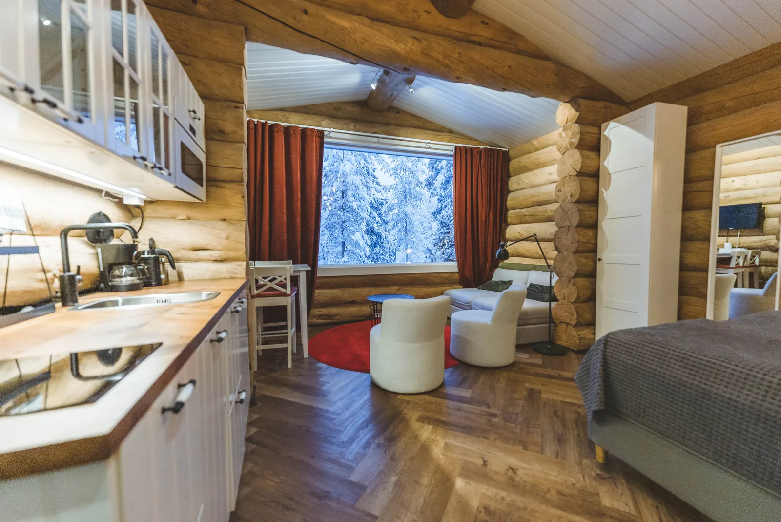 Offene Küchenzeile, Essecke und Bett in der gemütlichen Blockhütte