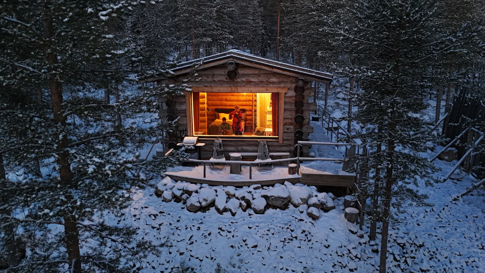 Gemütlich beleuchtete Blockhütte im verschneiten Wald