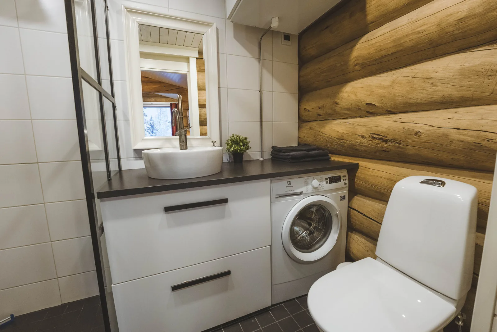 Bad der gemütlichen Blockhütte mit Waschmaschine und Dusche