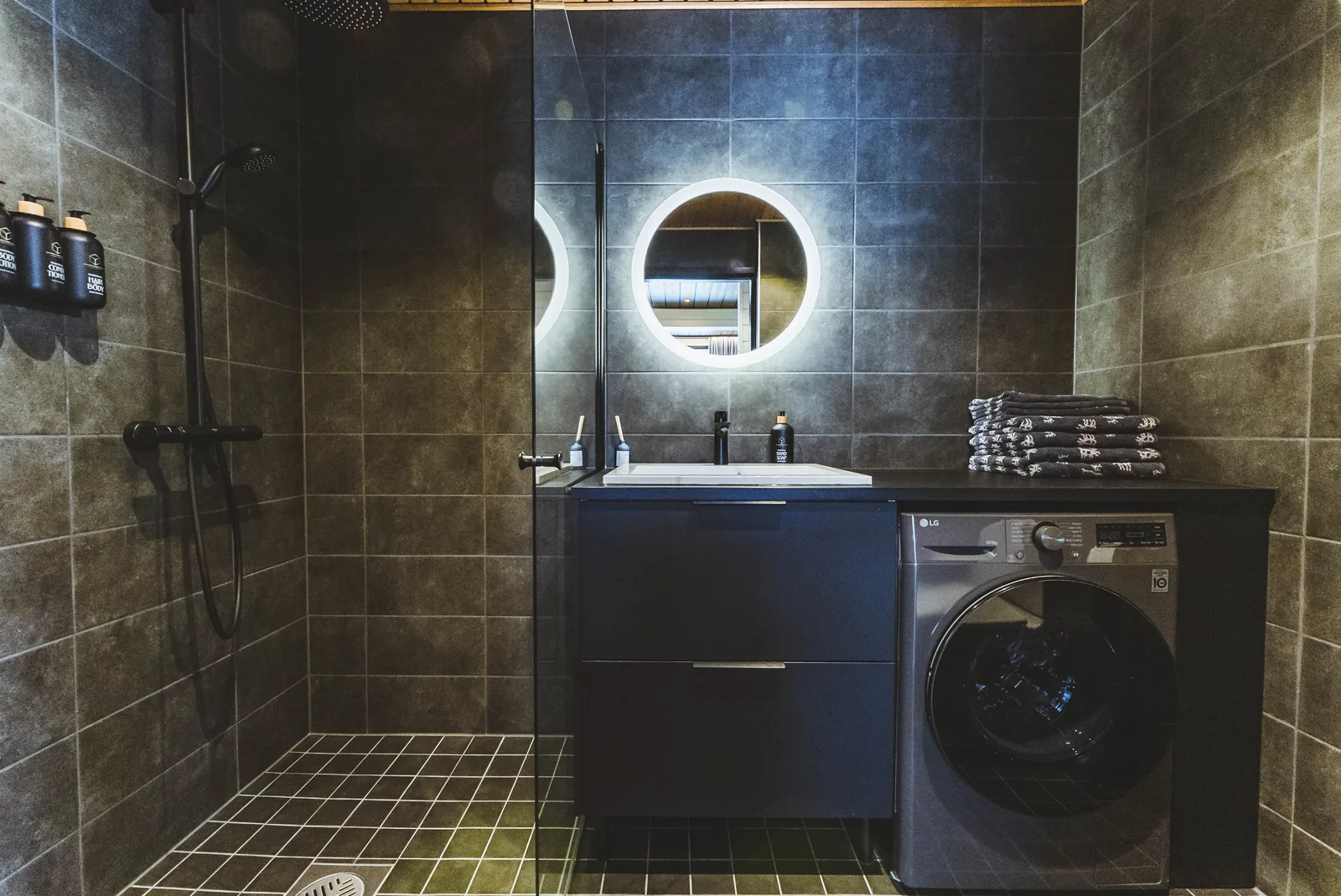 Bad der Invisible Suite mit Dusche, Waschtisch und Waschmaschine