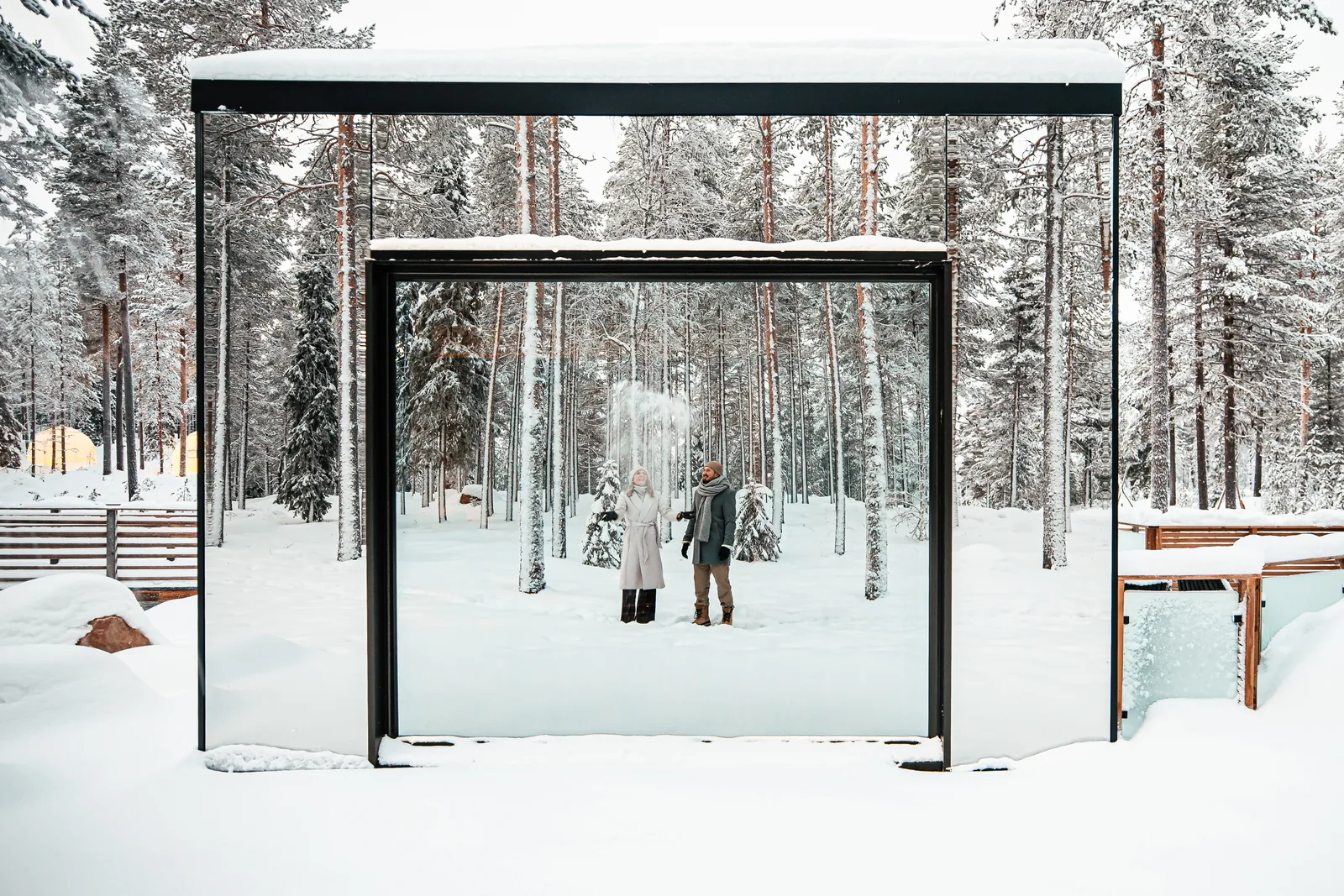 Gäste spazieren im Winter zwischen verspiegelten Invisible Suites